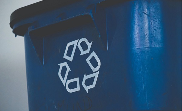 close up photo of large blue plastic recycle bin with recycle logo