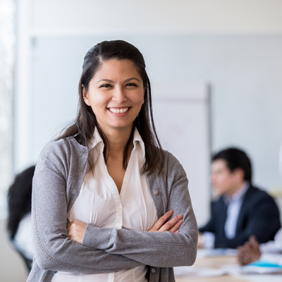 business woman in conference room, smiling with arms crossed